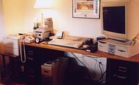 snorwood's crowded desk; dragon (main server) is Ultra 2 with monitor; DLT and 4mm tape drives are on the left and HP printer is at far left.  The keyboards are for dragon and anteater (SGI under desk).